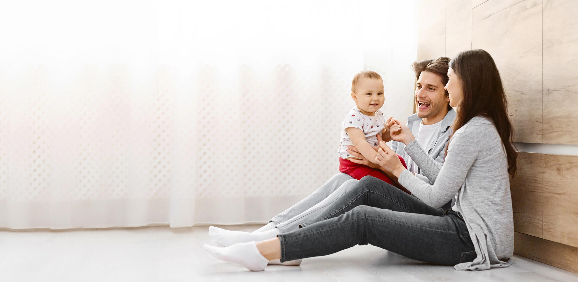 young family consisting mother father toddler sit together floor nutura gold